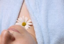 여름철 피부 진정 팩 만들기 woman wearing blue robe lying with cucumber on eye