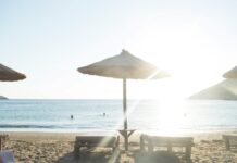 white patio umbrella near body of water