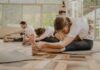 직장인에게 인기 급상승, 필라테스가 바꿔놓는 일상 건강 습관 a group of people doing yoga in a room