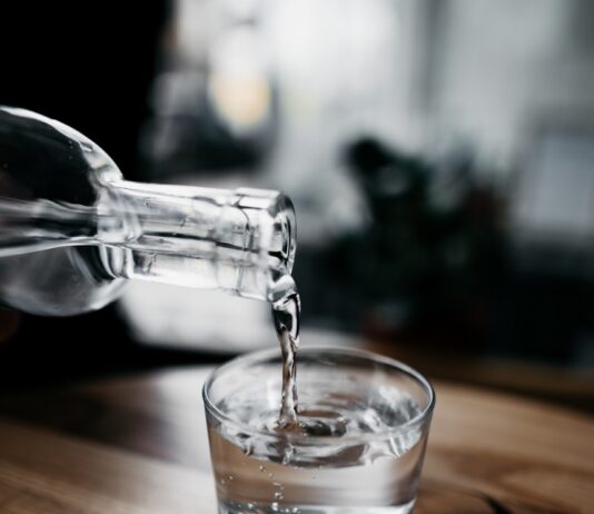 바쁜 현대인을 위한 ‘마이크로 운동’, 실생활 속 건강 챙기기 열풍 person holding bottle pouring water on drinking glass