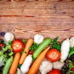 장 건강 개선, 이제 실천 가능한 방법으로 시작하세요 Fresh colorful vegetables arranged on a rustic wooden background.